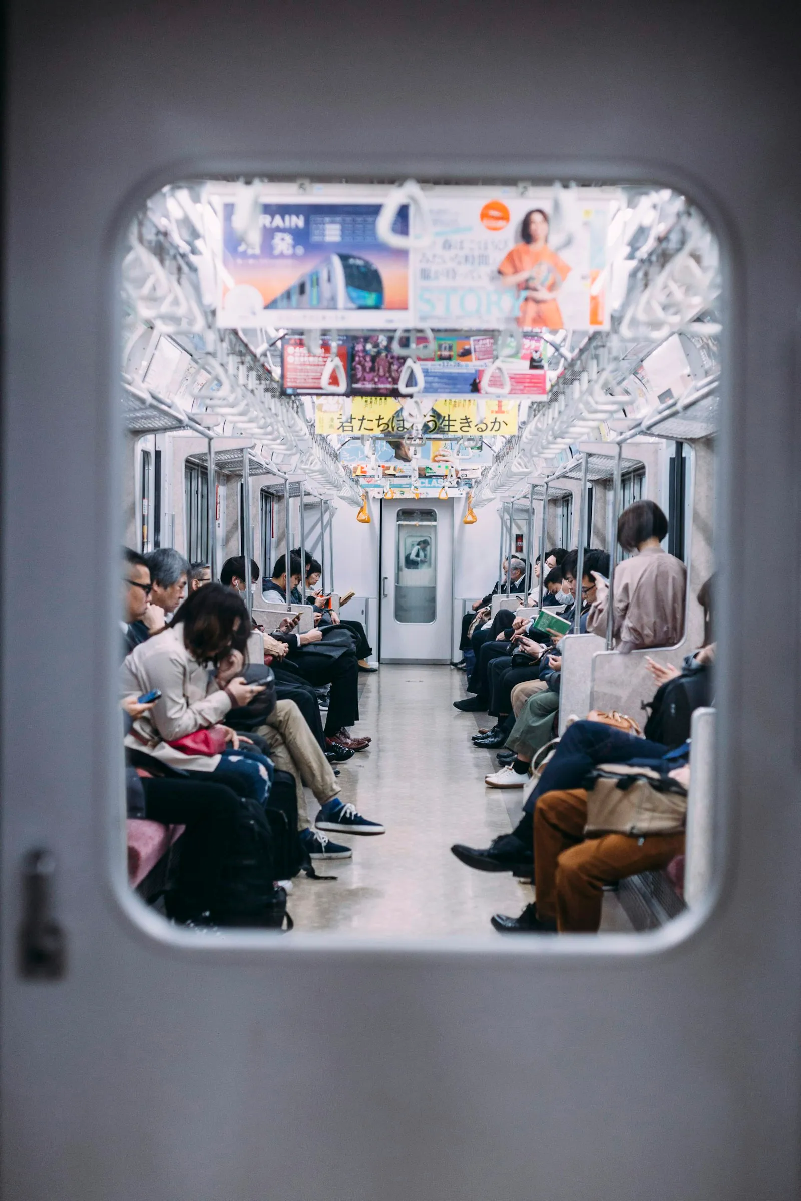 A carriage full of commuters, almost every one of them looking down at a phone